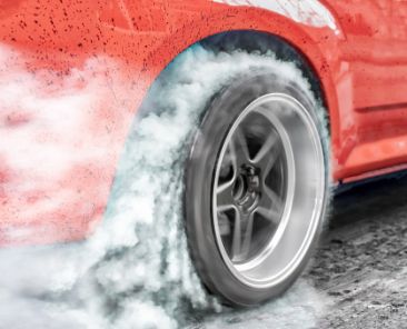 Drag racing car burns rubber off its tires in preparation for the race